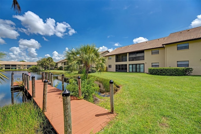 dock area featuring a water view and a lawn