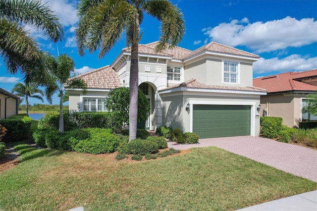 mediterranean / spanish house with a front yard and a garage