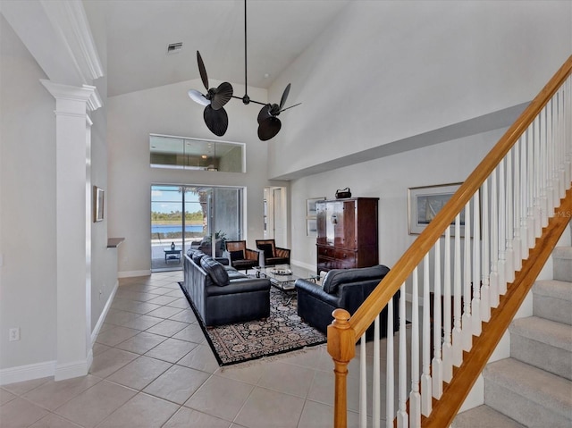 tiled living room featuring high vaulted ceiling, decorative columns, and ceiling fan