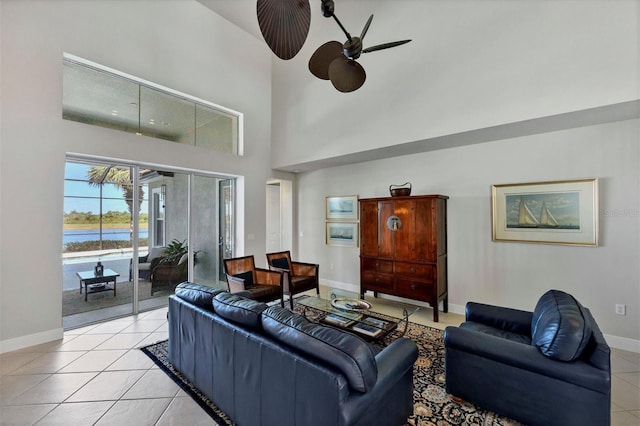 tiled living room with a high ceiling and ceiling fan