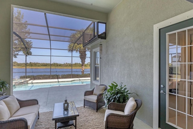 view of patio / terrace with a water view and glass enclosure