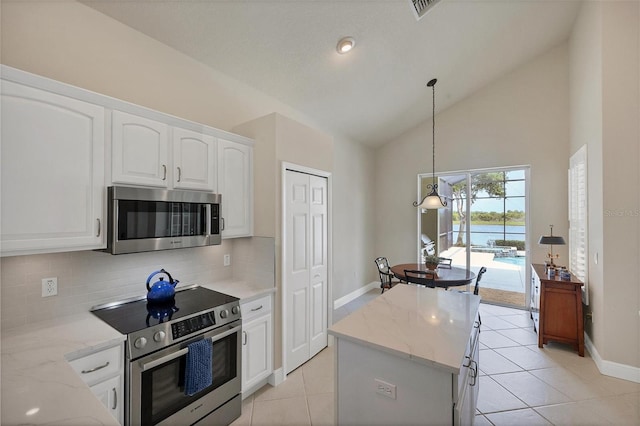 kitchen featuring high vaulted ceiling, light stone countertops, hanging light fixtures, white cabinetry, and appliances with stainless steel finishes