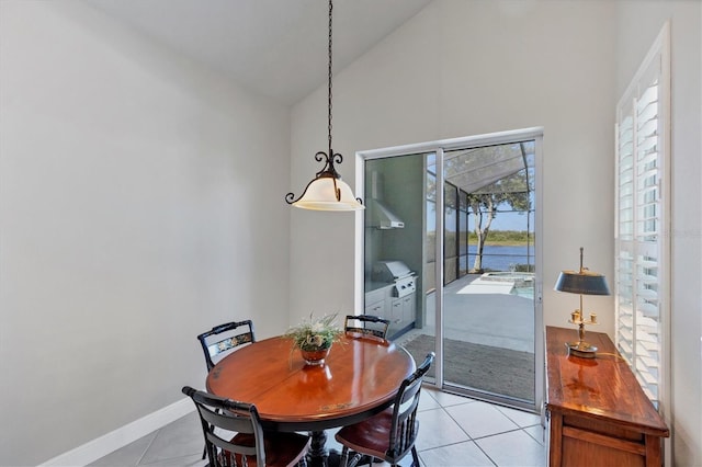 dining space featuring light tile patterned flooring and lofted ceiling