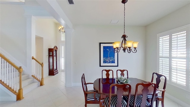 dining space with decorative columns and a chandelier