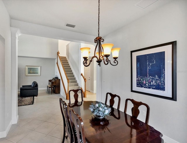 tiled dining room with ornate columns and a notable chandelier