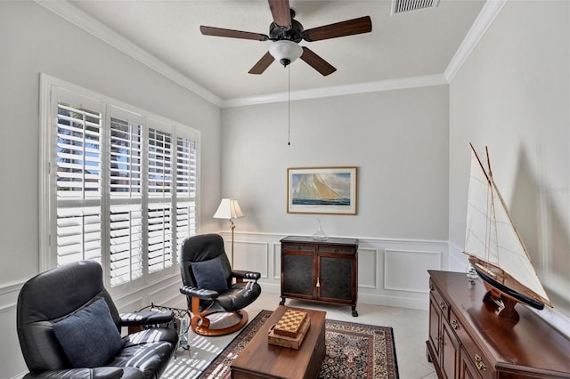 sitting room featuring ceiling fan, crown molding, and light tile patterned floors