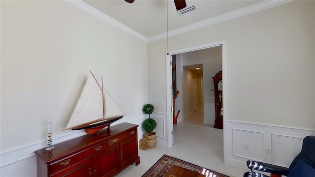 sitting room with light tile patterned flooring, crown molding, and ceiling fan