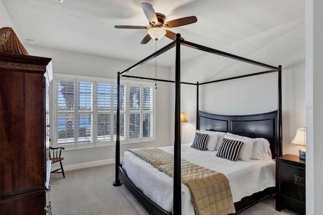 carpeted bedroom featuring a textured ceiling and ceiling fan