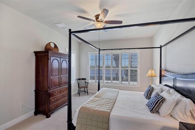 bedroom with ceiling fan, light colored carpet, and a textured ceiling