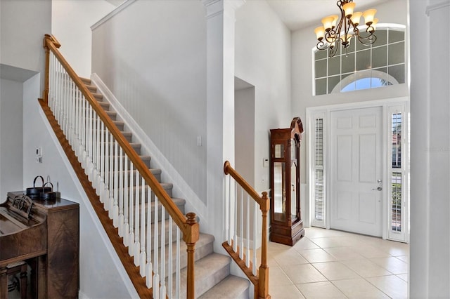 tiled foyer entrance featuring a notable chandelier and a towering ceiling