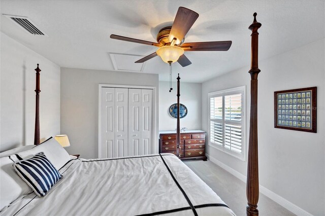 bedroom featuring light carpet, ceiling fan, and a closet