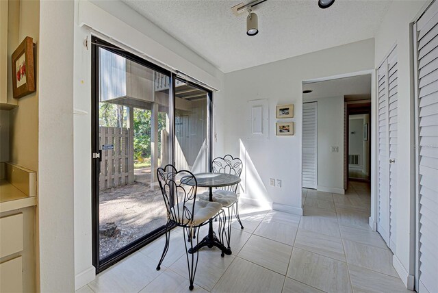 201 Woodland Dr Unit 201, Osprey, FL 34229 - dining area with a textured ceiling and rail lighting