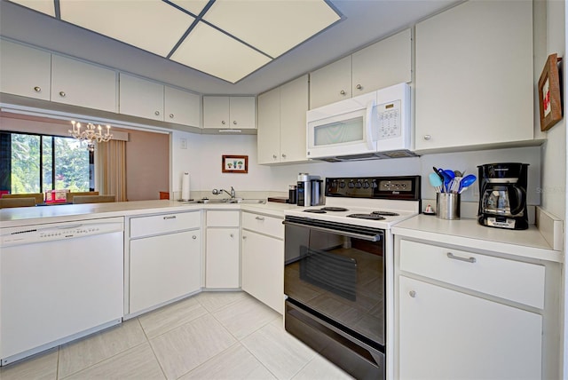 kitchen featuring light tile patterned flooring, sink, white appliances, white cabinetry, and an inviting chandelier