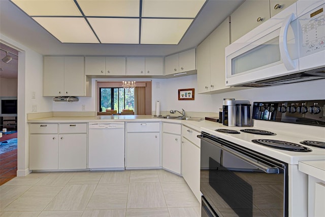 kitchen with white appliances, an inviting chandelier, sink, and white cabinets