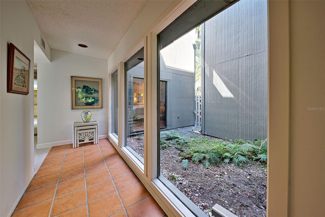201 Woodland Dr Unit 201, Osprey, FL 34229 - hall featuring tile patterned floors, baseboards, and a textured ceiling