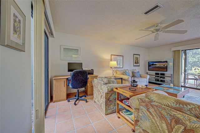 living room with ceiling fan, a textured ceiling, and light tile patterned flooring