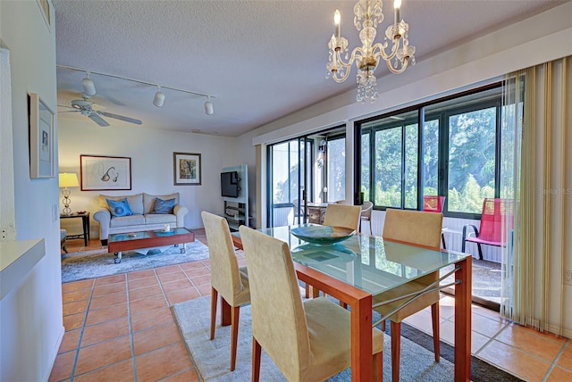 201 Woodland Dr Unit 201, Osprey, FL 34229 - tiled dining space featuring rail lighting, a chandelier, a textured ceiling, and a ceiling fan