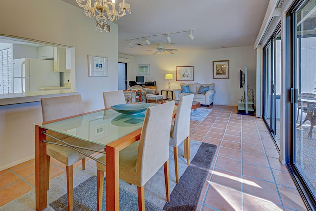 dining space featuring ceiling fan with notable chandelier, light tile patterned floors, and track lighting