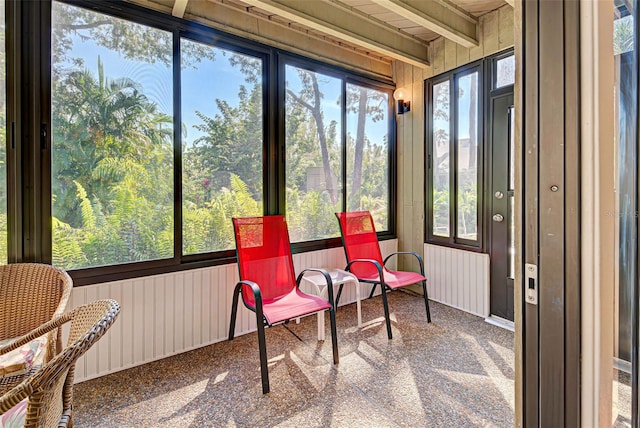 sunroom / solarium featuring beamed ceiling