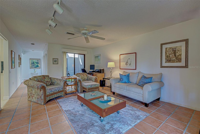 living room featuring a textured ceiling, tile patterned flooring, ceiling fan, and track lighting