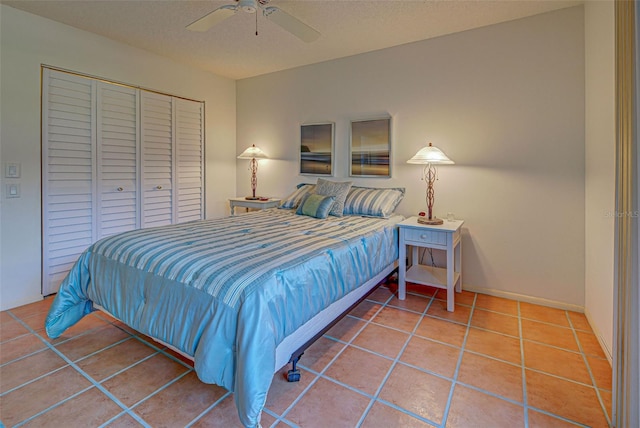 bedroom with tile patterned flooring, ceiling fan, and a closet