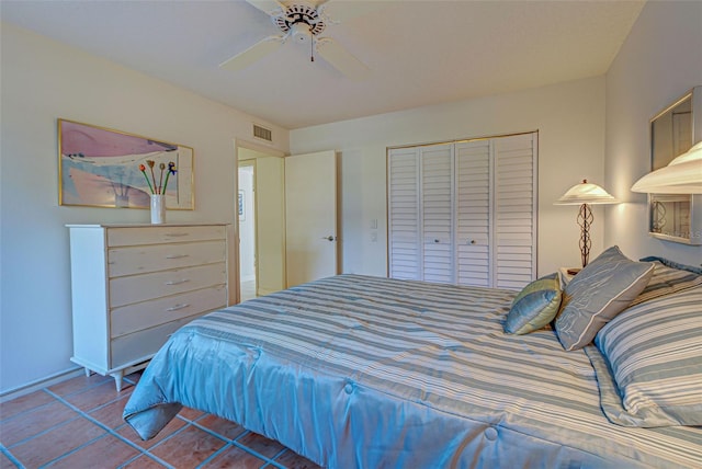 bedroom featuring ceiling fan, tile patterned floors, and a closet