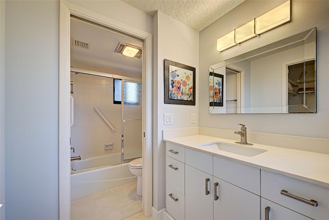 full bathroom featuring shower / bath combination with glass door, vanity, toilet, a textured ceiling, and tile patterned flooring