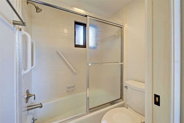 bathroom featuring shower / bath combination with glass door and toilet