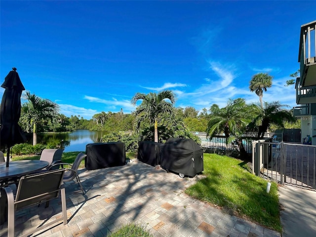 view of patio with area for grilling and a water view