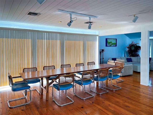 dining area featuring rail lighting, wood ceiling, and hardwood / wood-style floors