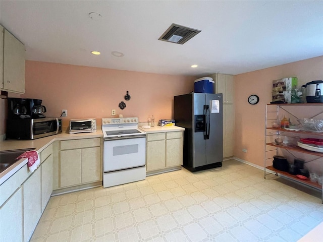 201 Woodland Dr Unit 201, Osprey, FL 34229 - kitchen with refrigerator with ice dispenser, white electric range oven, stainless steel microwave, light countertops, and recessed lighting