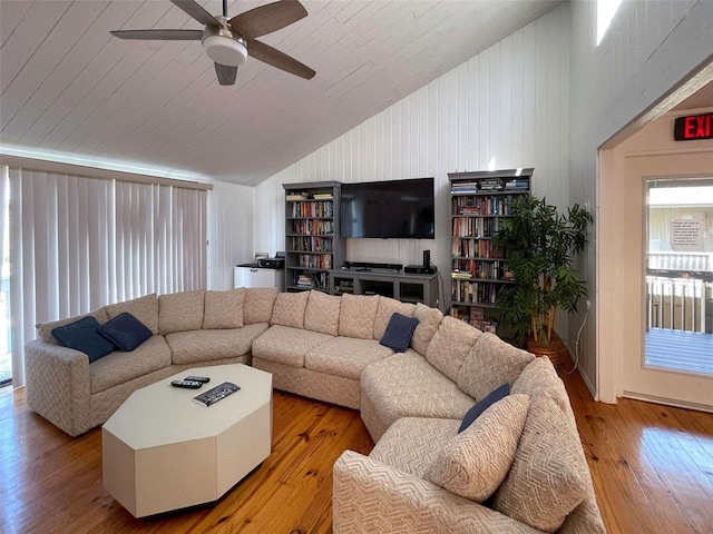 living room featuring high vaulted ceiling, wood walls, ceiling fan, and hardwood / wood-style flooring