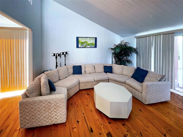 living room featuring wooden walls, hardwood / wood-style flooring, lofted ceiling, and wood ceiling