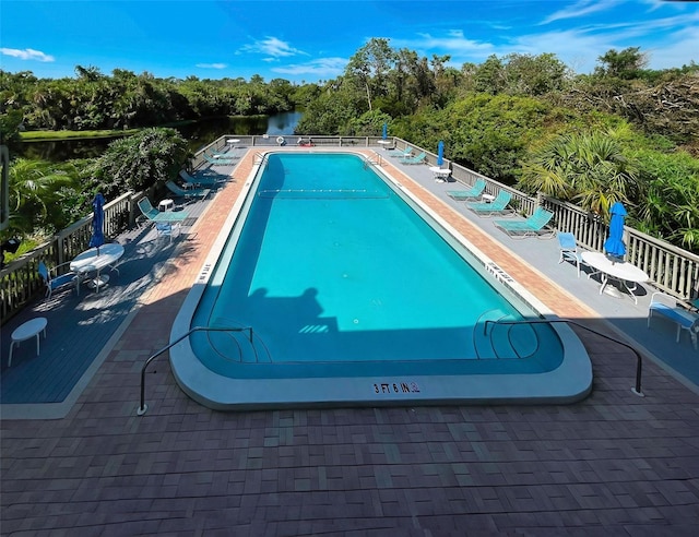 view of swimming pool with a patio and a water view