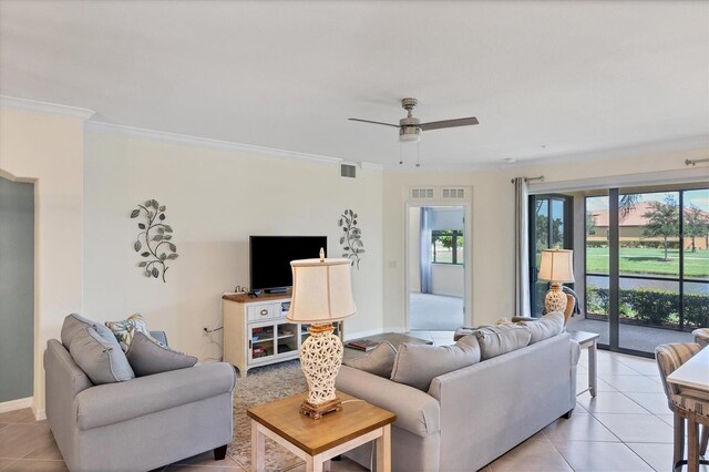 tiled living room with ceiling fan and crown molding