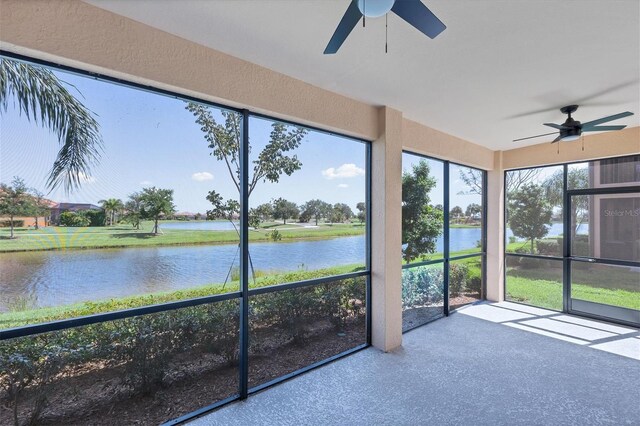 unfurnished sunroom with ceiling fan and a water view