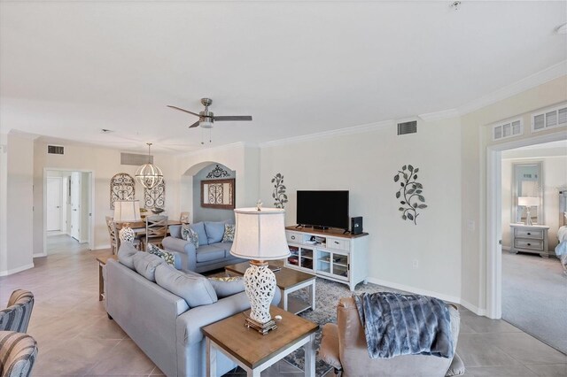 tiled living room with ceiling fan and ornamental molding