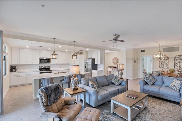 living room featuring light tile patterned flooring, sink, and ceiling fan with notable chandelier