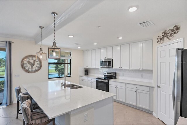 kitchen with a center island with sink, sink, stainless steel appliances, a kitchen bar, and white cabinetry