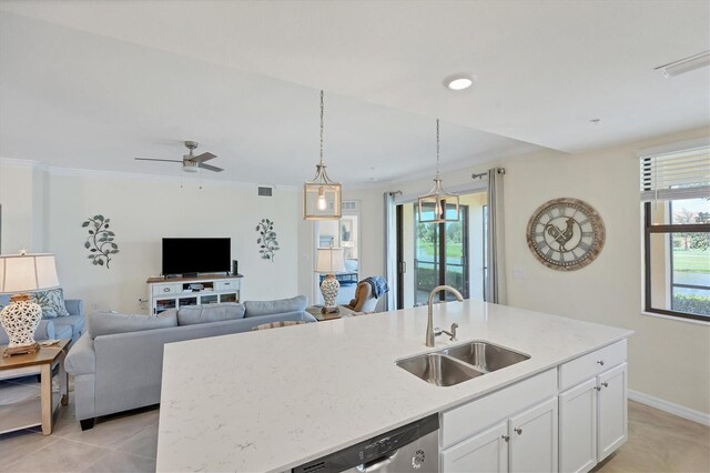 kitchen featuring a healthy amount of sunlight, a kitchen island with sink, sink, and white cabinets