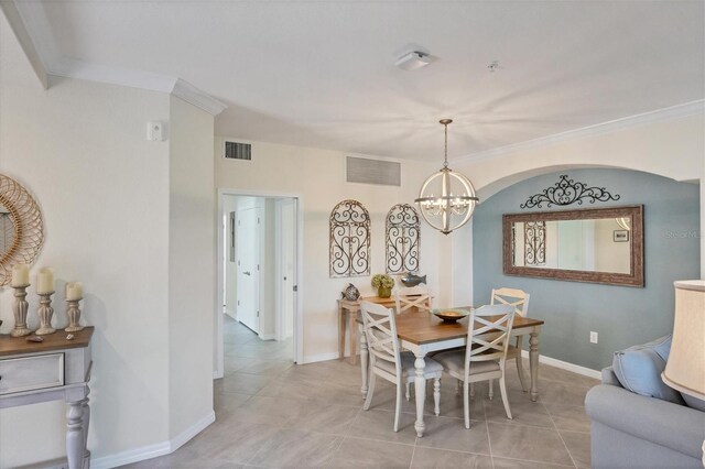 tiled dining area with crown molding and a notable chandelier