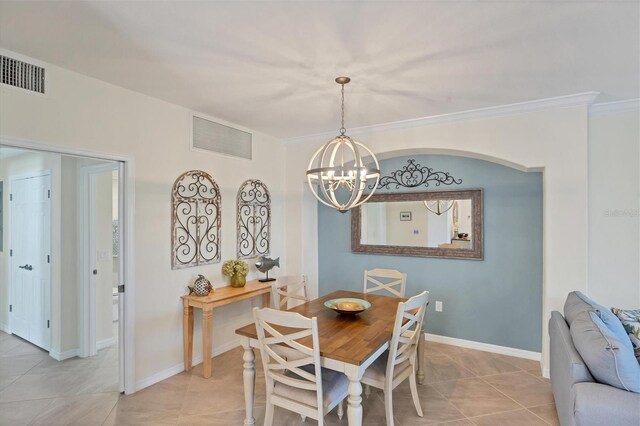 tiled dining area featuring ornamental molding and a chandelier