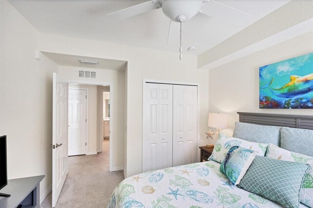 bedroom featuring ceiling fan, a closet, and light colored carpet