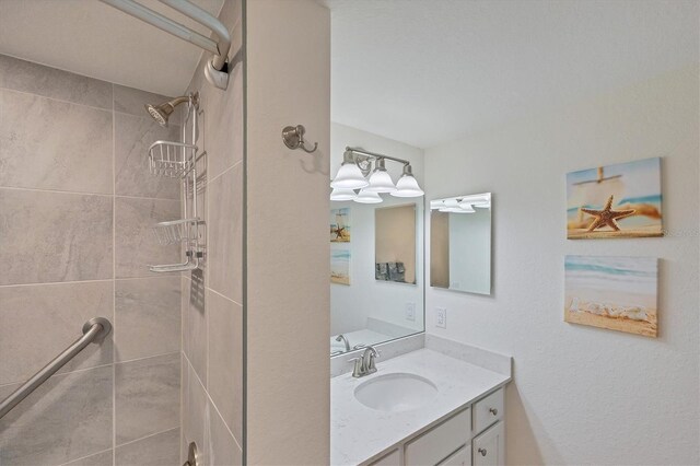 bathroom featuring vanity and tiled shower