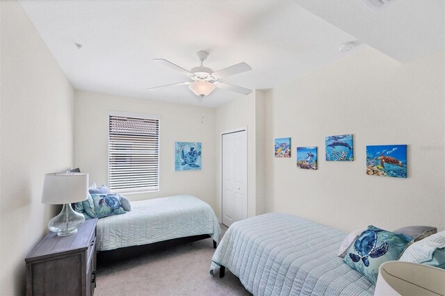 carpeted bedroom featuring ceiling fan and a closet