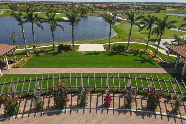 view of property's community with a water view and a lawn