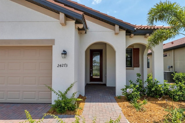 entrance to property with a garage and central AC