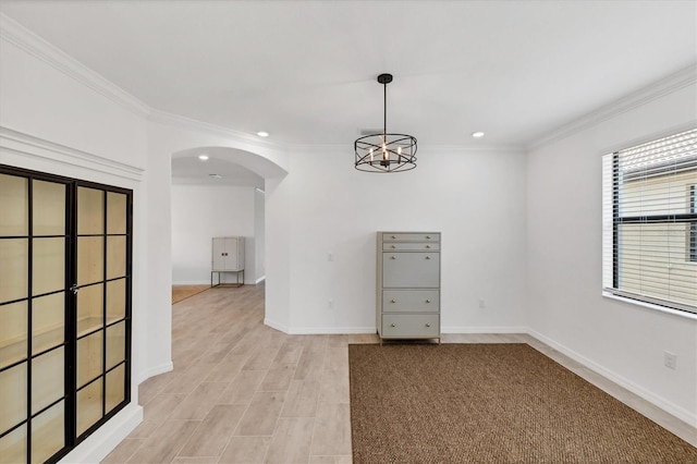 unfurnished room with ornamental molding and a notable chandelier