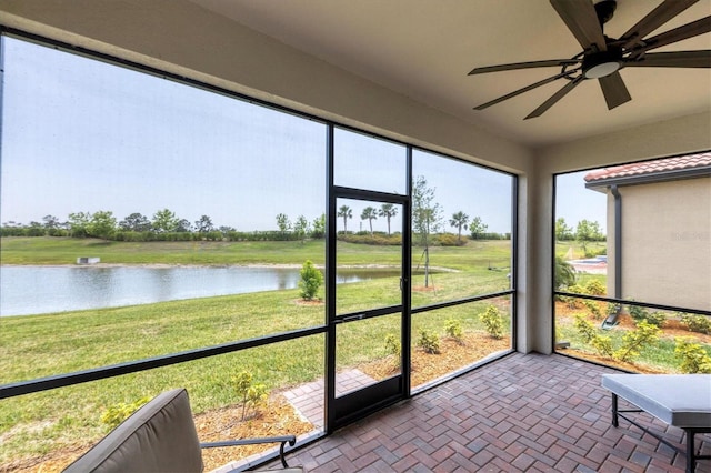 unfurnished sunroom with a water view and ceiling fan