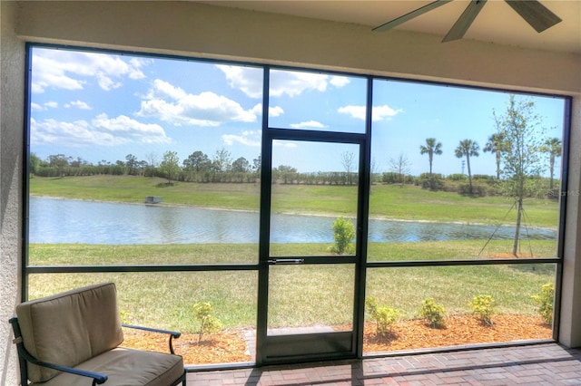 sunroom / solarium featuring a water view and ceiling fan